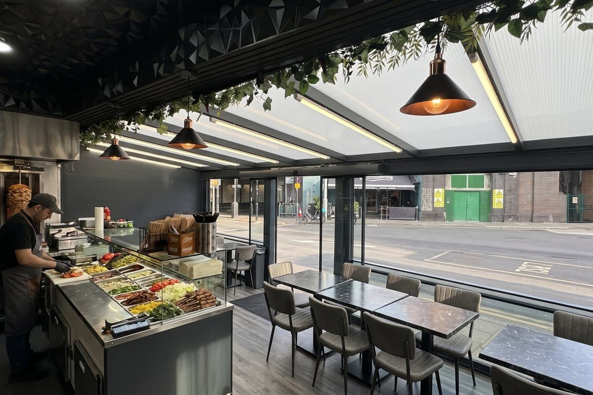 Interior view of customer dining tables under an enclosed commercial veranda.