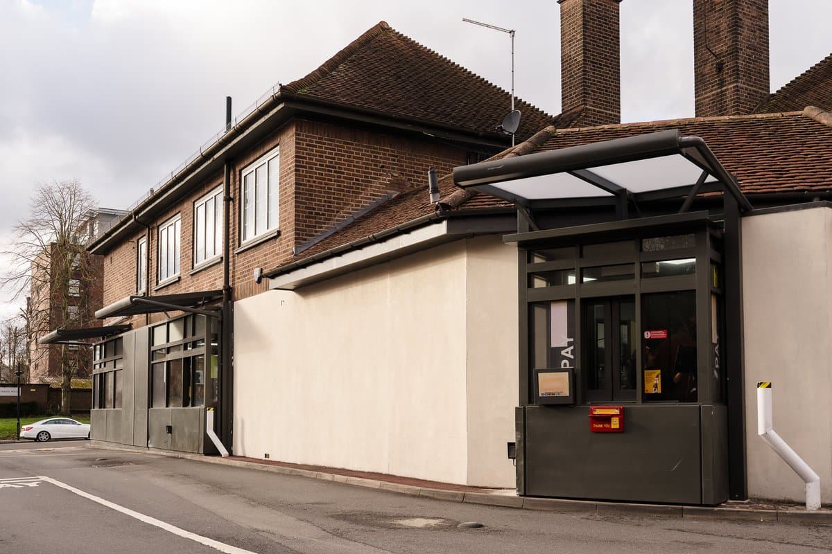 Wall-mounted drive-through collection canopy installed along service lane.