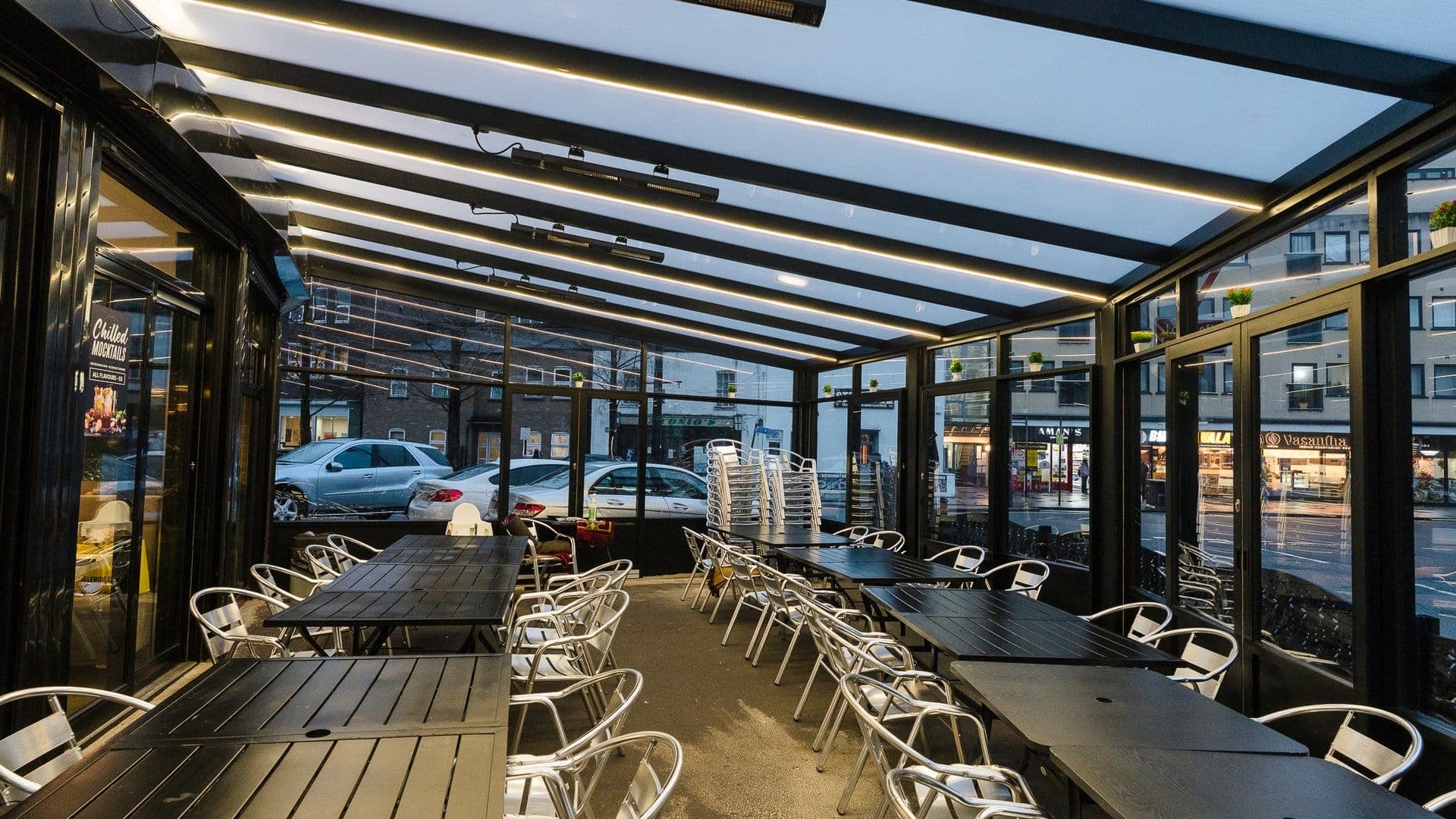 Enclosed commercial dining veranda with glass sliding doors at a restaurant venue in the South East