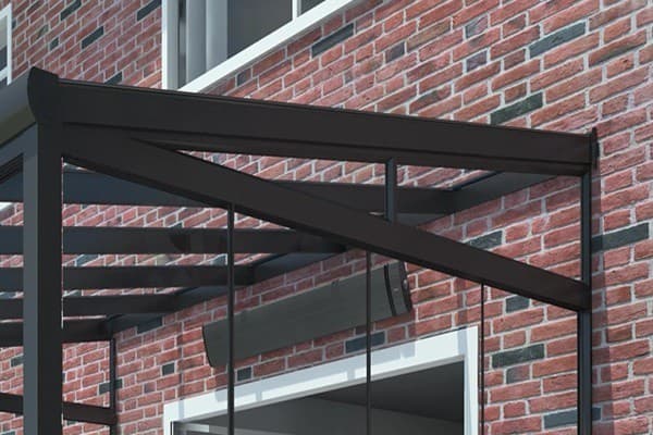 Clear laminated safety glass triangular wedge panel capping the sloped side gable of a residential glass roof veranda