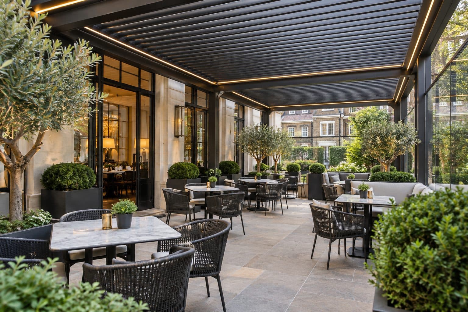 Restaurant terrace with a louvred aluminium pergola, LED perimeter lighting, glass side walls and outdoor seating