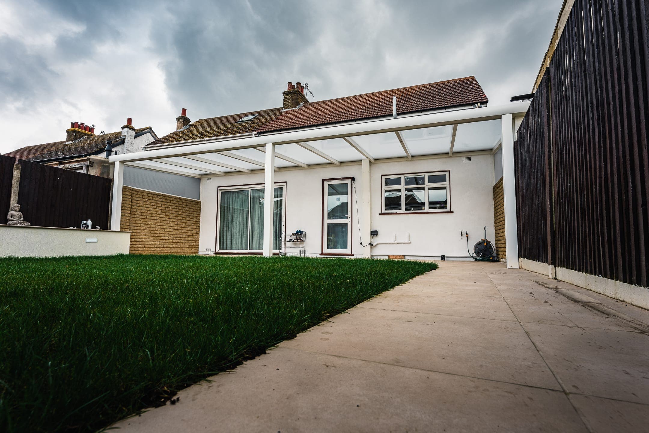 White attached polycarbonate veranda over a paved patio